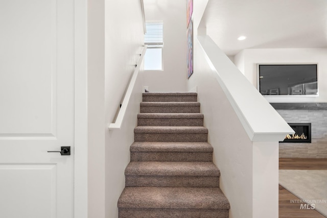 1210 Stirling Meadows Ct, Middleton, ID 83644 - staircase featuring wood finished floors, a glass covered fireplace, and recessed lighting