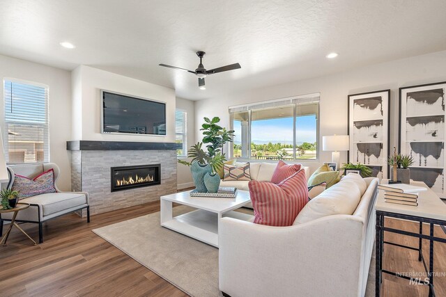 1210 Stirling Meadows Ct, Middleton, ID 83644 - living room with wood finished floors, a glass covered fireplace, a ceiling fan, and recessed lighting