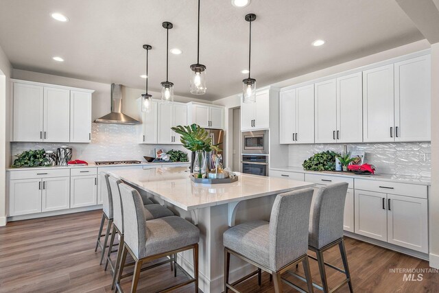 1210 Stirling Meadows Ct, Middleton, ID 83644 - kitchen featuring wall chimney exhaust hood, stainless steel appliances, white cabinets, and recessed lighting
