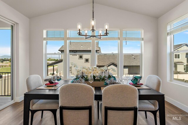 1210 Stirling Meadows Ct, Middleton, ID 83644 - dining area with a chandelier, wood finished floors, vaulted ceiling, and baseboards