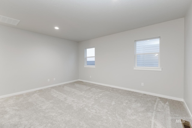 carpeted spare room featuring recessed lighting, visible vents, and baseboards