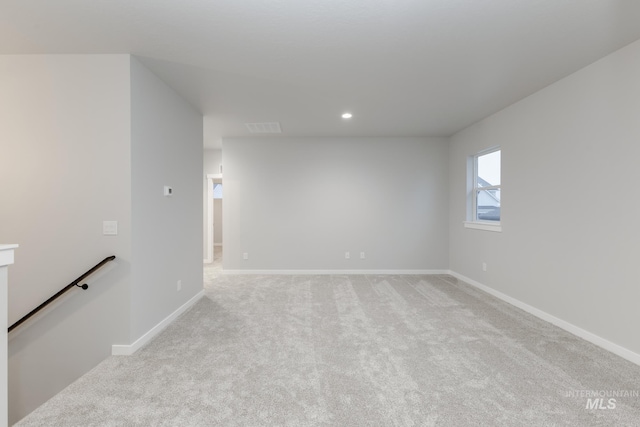 spare room featuring light carpet, recessed lighting, visible vents, and baseboards