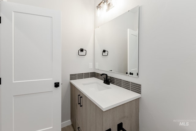 bathroom with tasteful backsplash and vanity