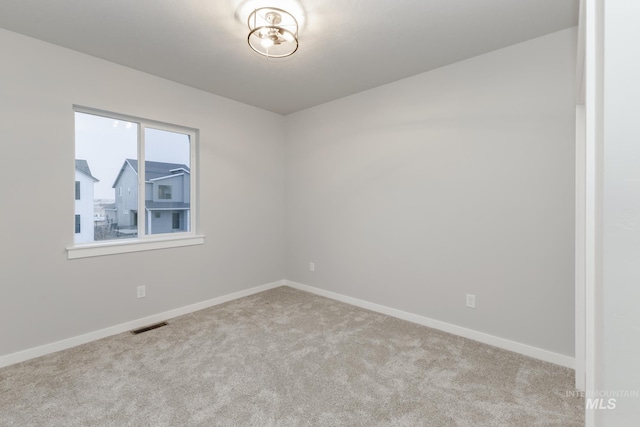 empty room featuring baseboards, visible vents, and carpet flooring