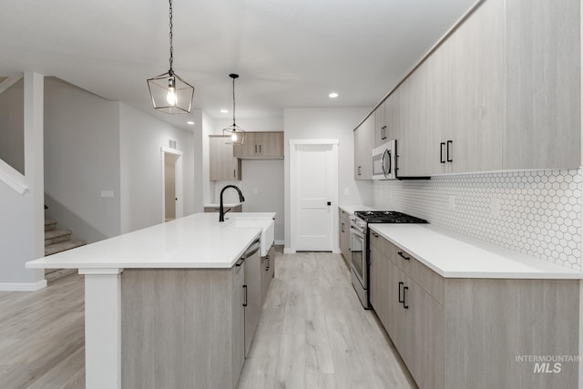 kitchen featuring light wood-style flooring, modern cabinets, appliances with stainless steel finishes, and light brown cabinetry