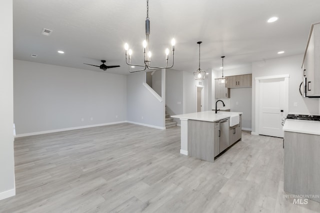 kitchen featuring light wood finished floors, light countertops, appliances with stainless steel finishes, and baseboards