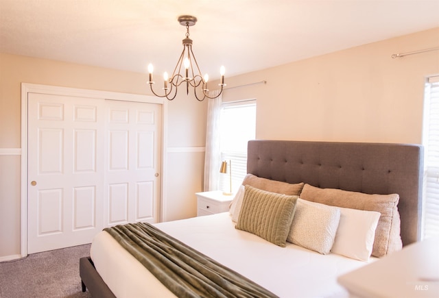 bedroom featuring a closet, carpet floors, and a chandelier