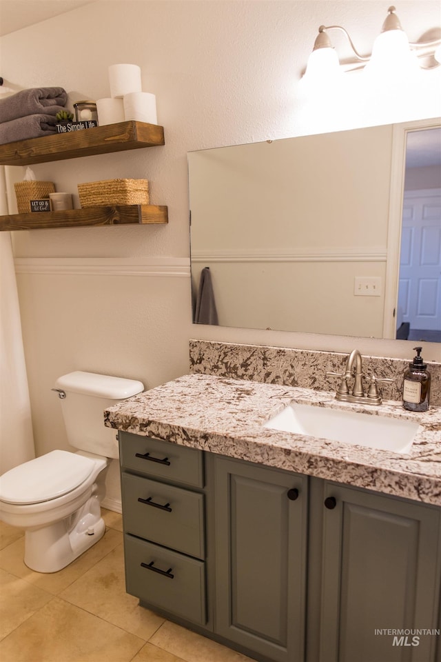 bathroom featuring tile patterned flooring, vanity, and toilet