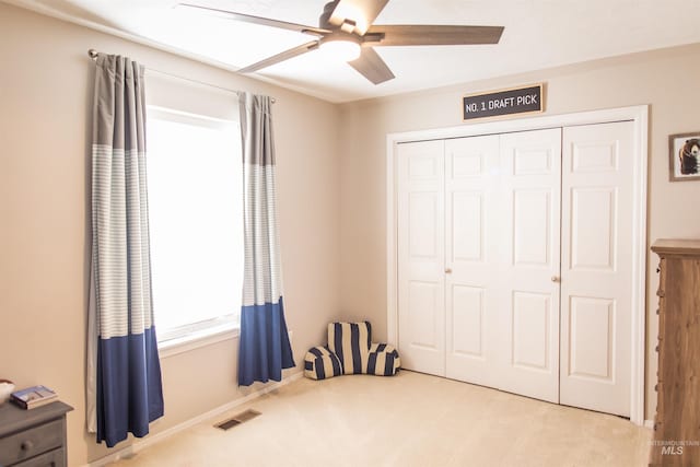 carpeted bedroom with a closet and ceiling fan