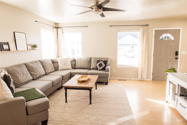 living room featuring ceiling fan and light hardwood / wood-style floors