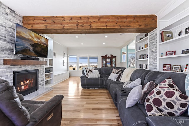 living room with a stone fireplace, recessed lighting, built in features, light wood finished floors, and crown molding