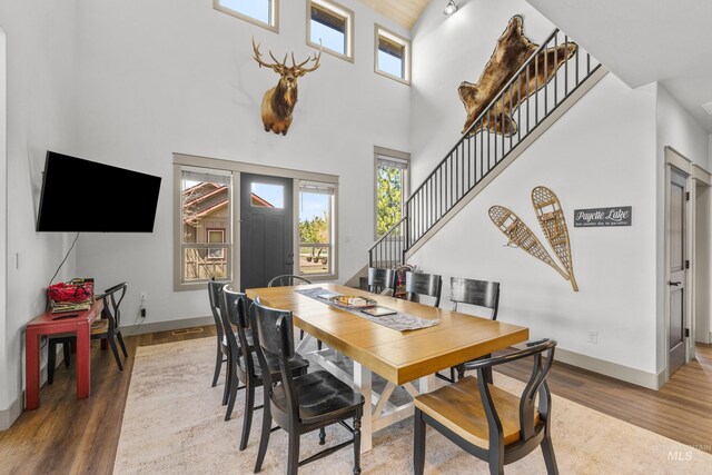 1089 Graham Dr, Mccall, ID 83638 - dining space featuring a high ceiling, stairway, baseboards, and wood finished floors