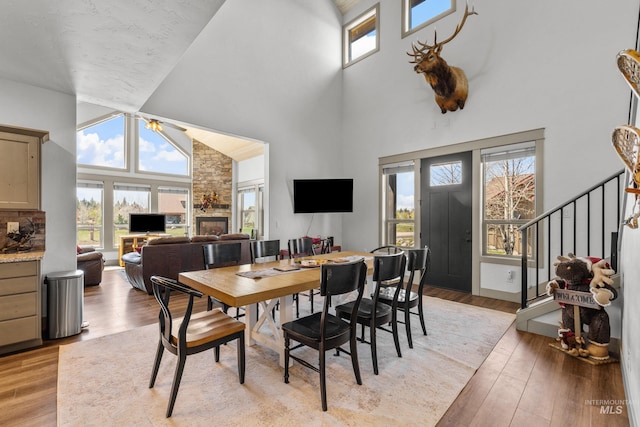 1089 Graham Dr, Mccall, ID 83638 - dining room with a towering ceiling, stairs, light wood finished floors, and a stone fireplace