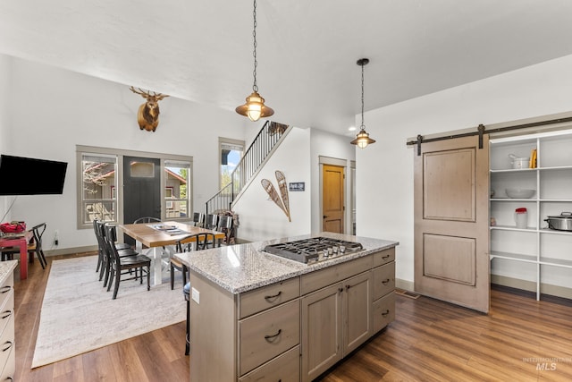 1089 Graham Dr, Mccall, ID 83638 - kitchen with stainless steel gas stovetop, dark wood finished floors, a barn door, hanging light fixtures, and baseboards