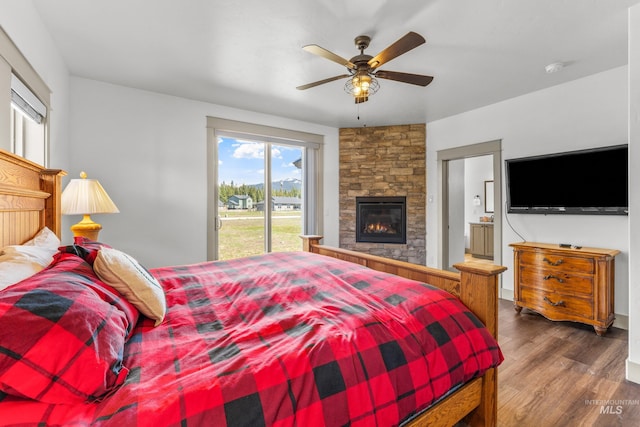 1089 Graham Dr, Mccall, ID 83638 - bedroom with access to outside, wood finished floors, a stone fireplace, connected bathroom, and ceiling fan
