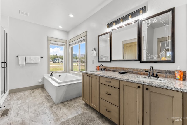 1089 Graham Dr, Mccall, ID 83638 - bathroom featuring marble finish floors, double vanity, a garden tub, baseboards, and recessed lighting