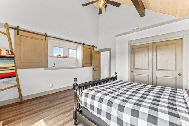 1089 Graham Dr, Mccall, ID 83638 - bedroom with beamed ceiling, light wood-style flooring, a barn door, a closet, and ceiling fan