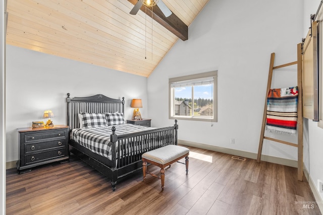1089 Graham Dr, Mccall, ID 83638 - bedroom with a barn door, wood finished floors, baseboards, wooden ceiling, and a ceiling fan