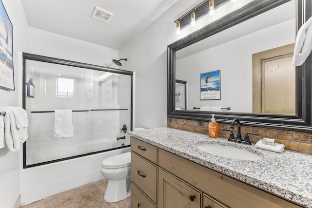 1089 Graham Dr, Mccall, ID 83638 - bathroom with decorative backsplash, toilet, combined bath / shower with glass door, vanity, and tile patterned floors