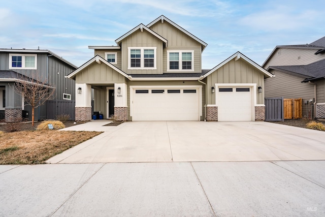 craftsman-style home featuring driveway, fence, board and batten siding, an attached garage, and brick siding