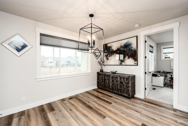 dining room featuring visible vents, baseboards, light wood-type flooring, and an inviting chandelier