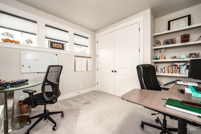 office space featuring light carpet and baseboards