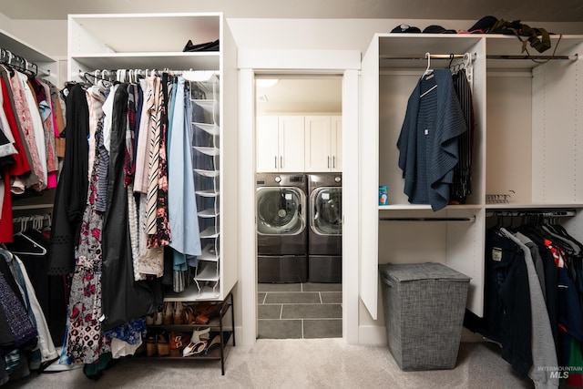 walk in closet with washing machine and clothes dryer and carpet flooring