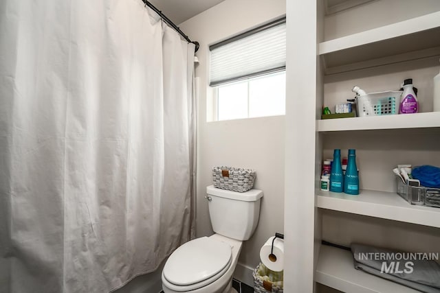 full bath with toilet and a shower with curtain