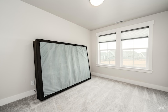 carpeted empty room featuring baseboards and visible vents