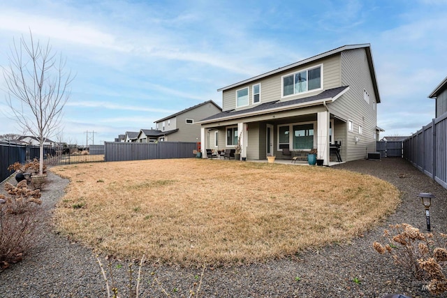 back of property featuring a patio area, a yard, a fenced backyard, and central AC