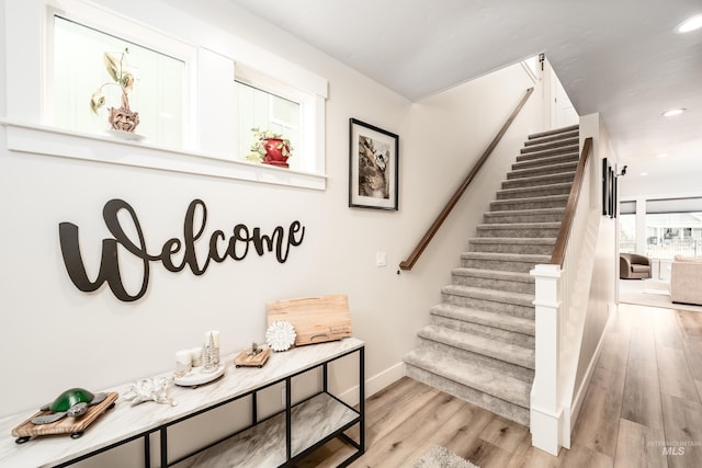 stairway featuring recessed lighting, baseboards, and wood finished floors