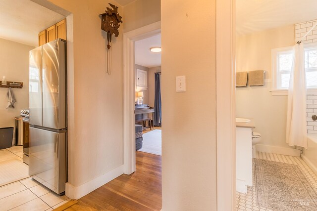 corridor with light tile patterned floors and baseboards