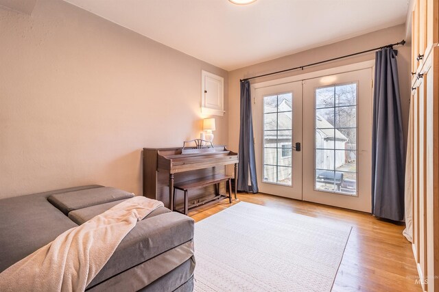 living area with light wood-style flooring and french doors
