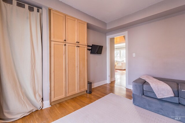 sitting room with baseboards and light wood finished floors