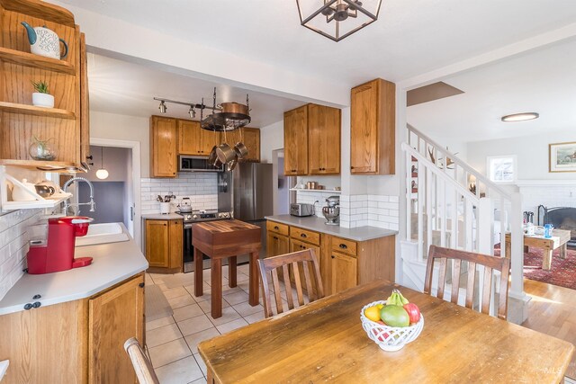 kitchen featuring a sink, light countertops, brown cabinets, and stainless steel appliances