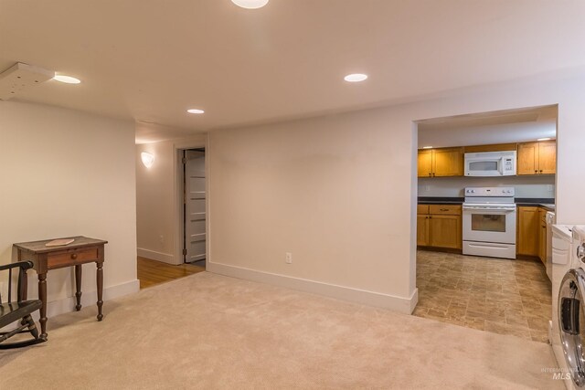 kitchen featuring light carpet, recessed lighting, white appliances, and washer / clothes dryer
