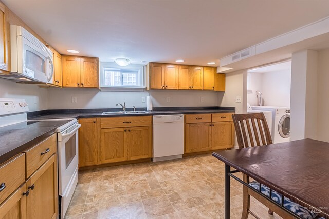 kitchen featuring visible vents, a sink, washer / clothes dryer, dark countertops, and white appliances