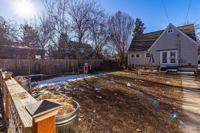 view of yard featuring french doors and fence