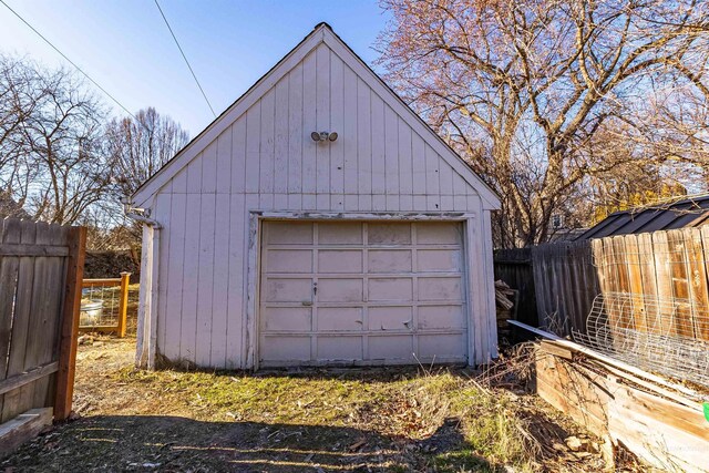 detached garage featuring fence