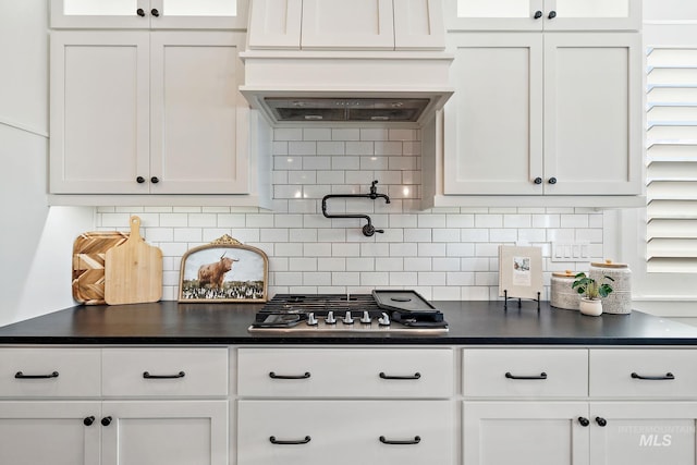 kitchen with white cabinets, backsplash, and stainless steel gas cooktop