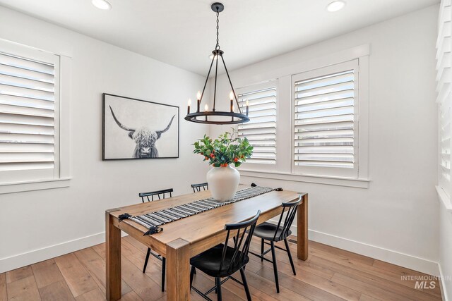 dining space with a notable chandelier, light hardwood / wood-style floors, and plenty of natural light