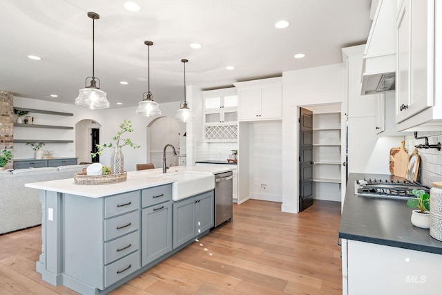 kitchen featuring sink, pendant lighting, stainless steel appliances, and white cabinets