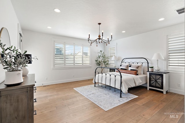 bedroom featuring light hardwood / wood-style flooring and a chandelier