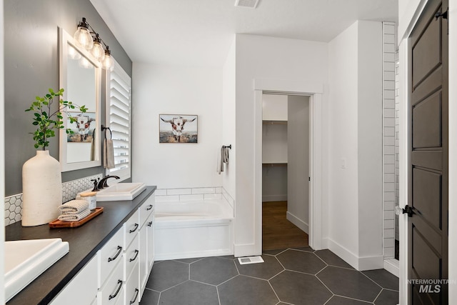 bathroom with vanity, a tub to relax in, and tile patterned floors