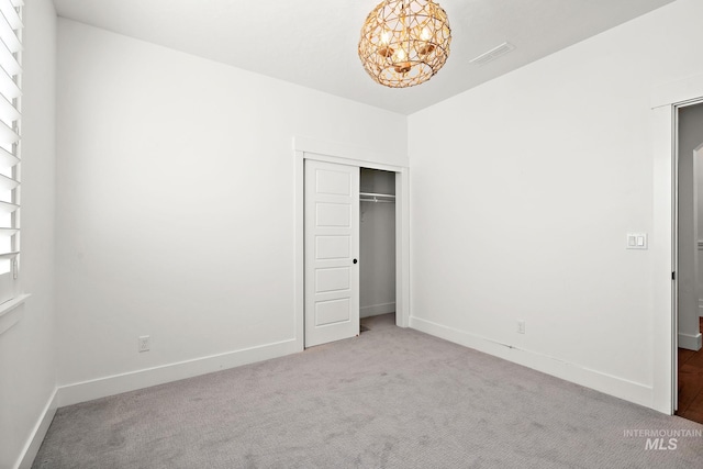 unfurnished bedroom featuring light colored carpet and a closet