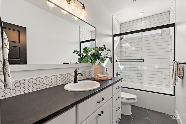 full bathroom featuring tile patterned flooring, decorative backsplash, bath / shower combo with glass door, vanity, and toilet