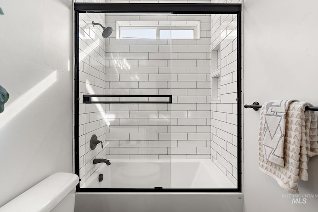 bathroom with shower / bath combination with glass door and toilet