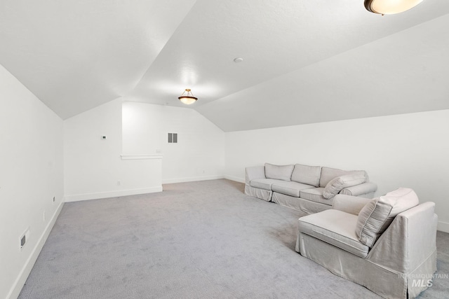 additional living space featuring vaulted ceiling and light colored carpet