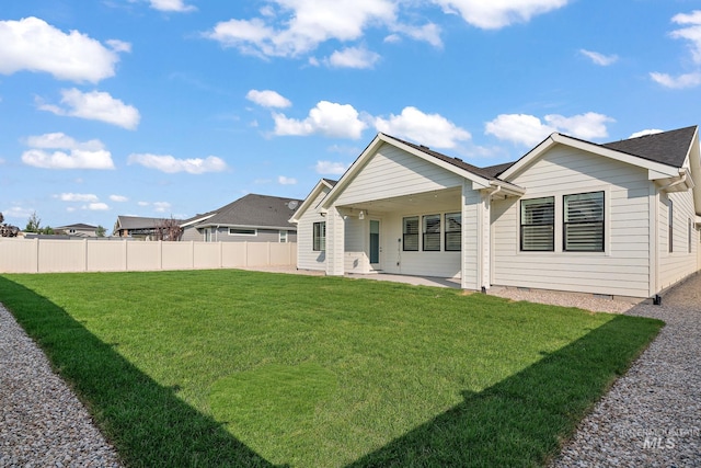 back of property with a lawn and a patio