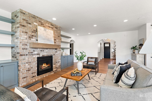 living room featuring light wood-type flooring and a fireplace